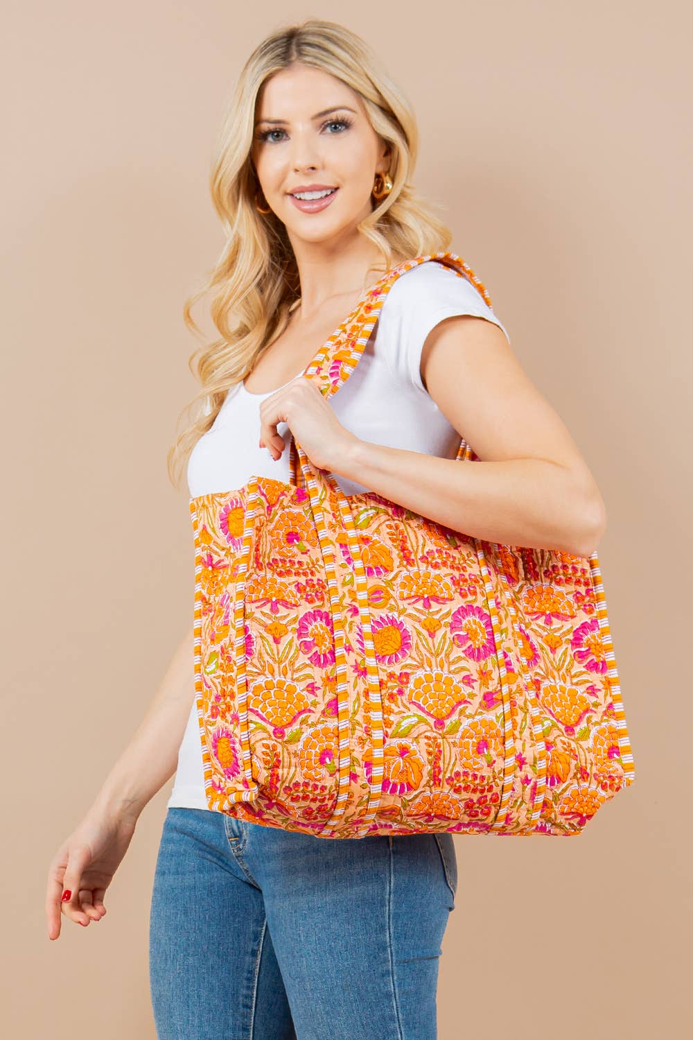 Woman holding a colorful patterned bag against a beige background