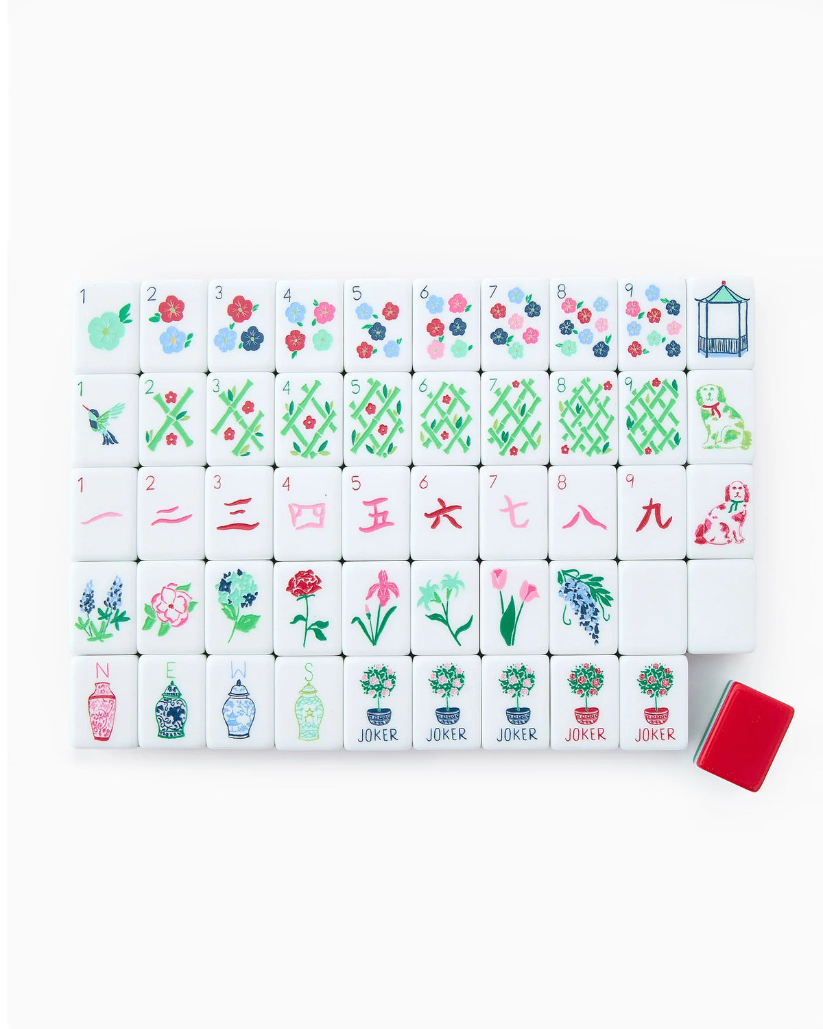 A set of Nantucket Tiles in red, light blue, and kelly green colors with various patterns and designs, displayed on a white surface alongside a red dice/coin bag.